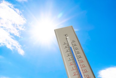 Image of Weather thermometer with high temperature outdoors on hot sunny day. Heat stroke warning