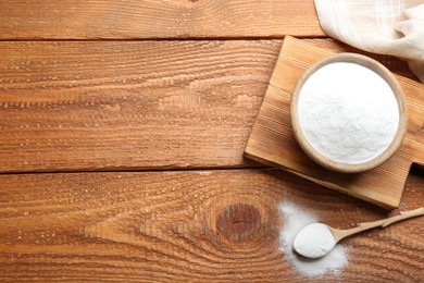 Photo of Baking soda on wooden table, flat lay. Space for text