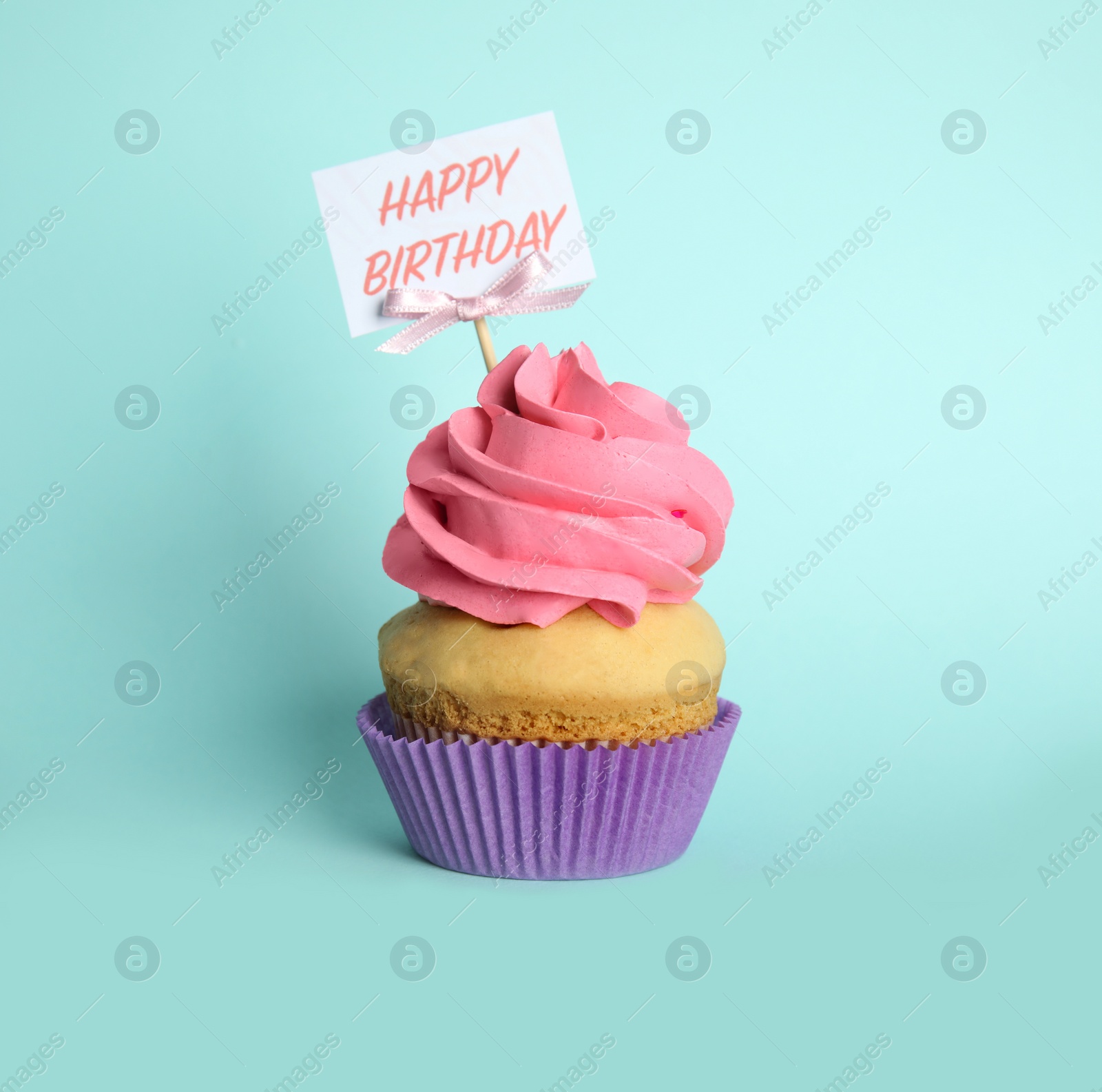 Photo of Beautiful birthday cupcake on light blue background
