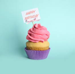 Photo of Beautiful birthday cupcake on light blue background