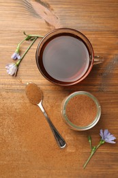 Cup of delicious chicory drink, powder and flowers on wooden table, flat lay
