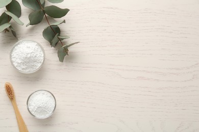 Photo of Tooth powder, brush and eucalyptus on white wooden table, flat lay. Space for text