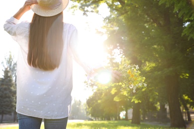 Photo of Young woman with beautiful bouquet outdoors on sunny day, back view