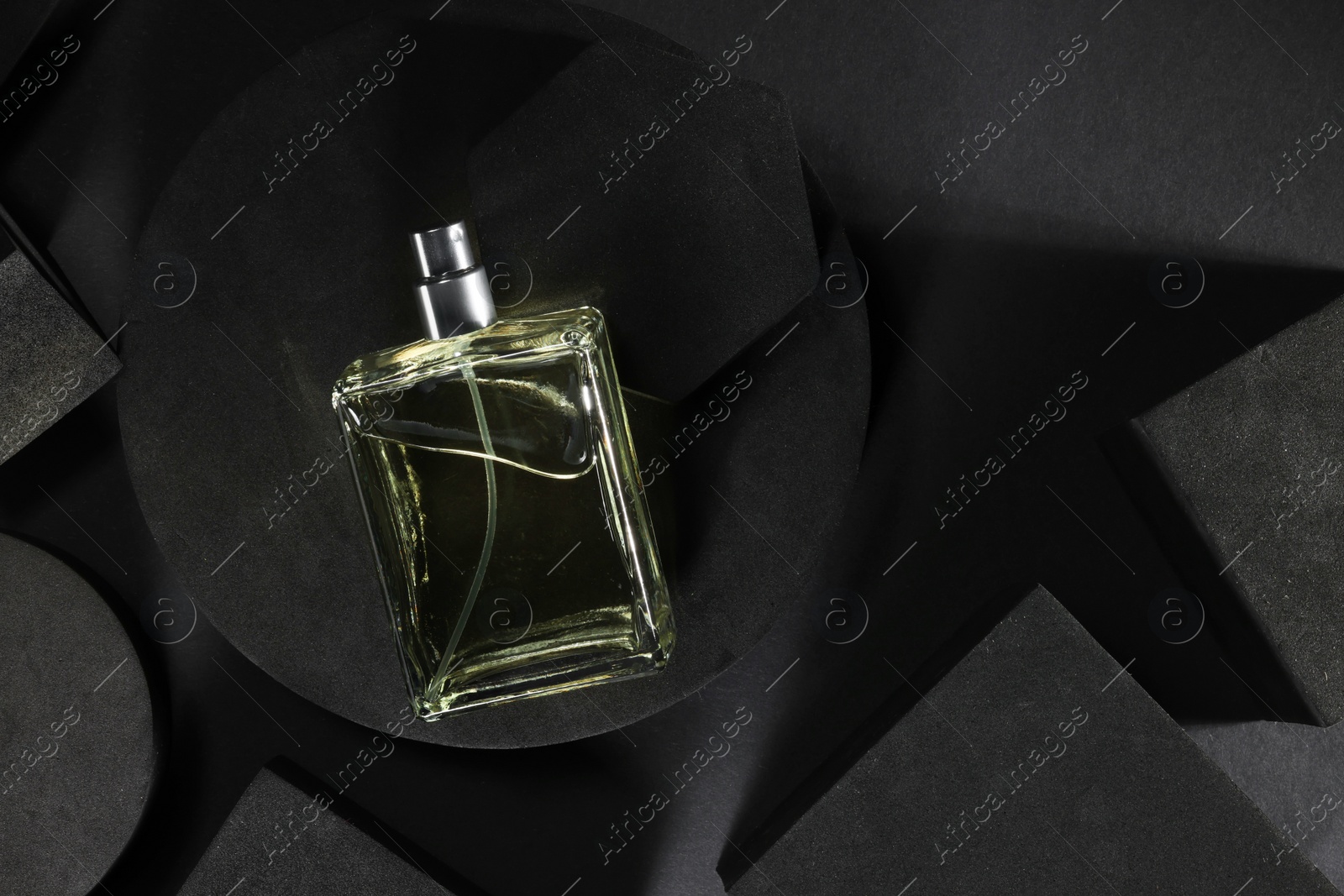 Photo of Stylish presentation of luxury men`s perfume in bottle on black background, top view. Space for text