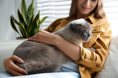Photo of Young woman with cute cat at home. Fluffy pet