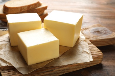 Wooden board with fresh butter on table, closeup