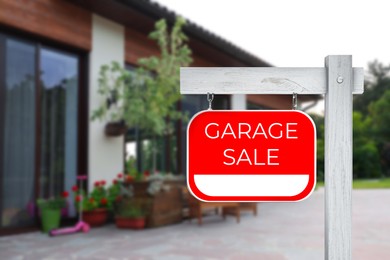 Image of Sign with text GARAGE SALE and near modern house