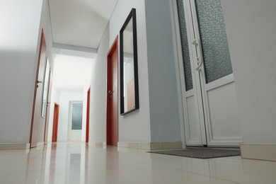 Photo of Modern empty office corridor with white walls and mirror