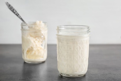 Jars with milkshake and tasty vanilla ice cream on table