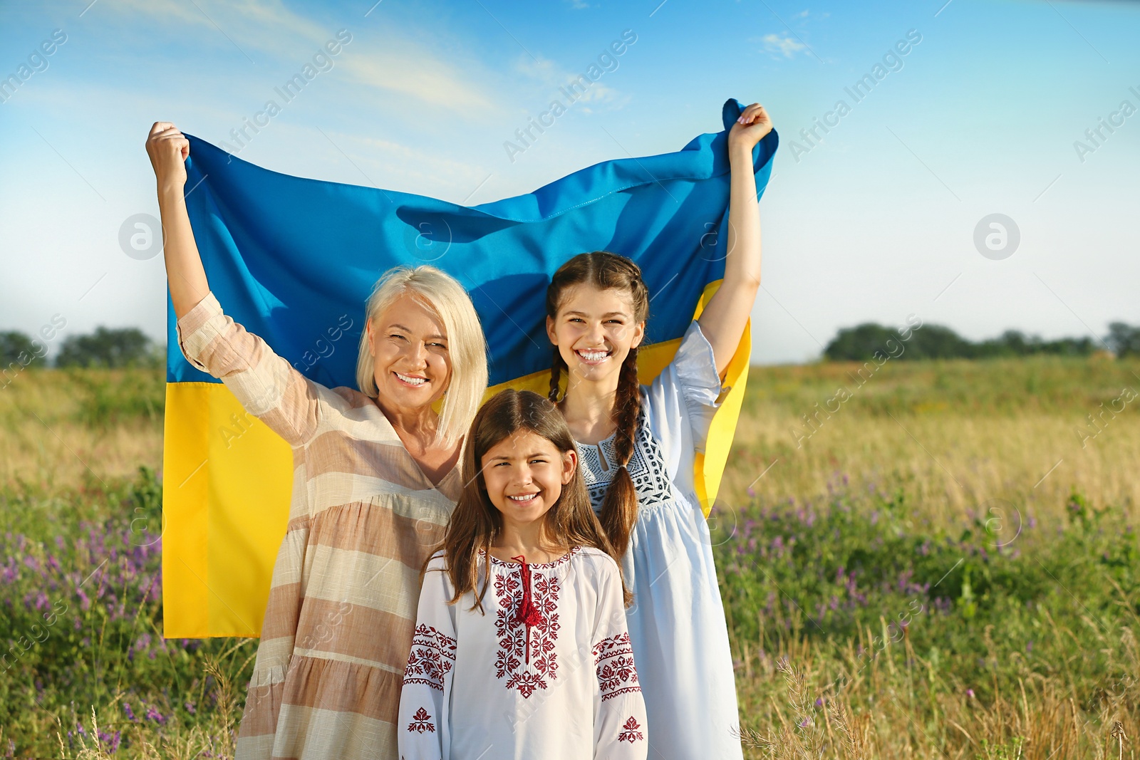 Photo of Happy family with national flag of Ukraine in field