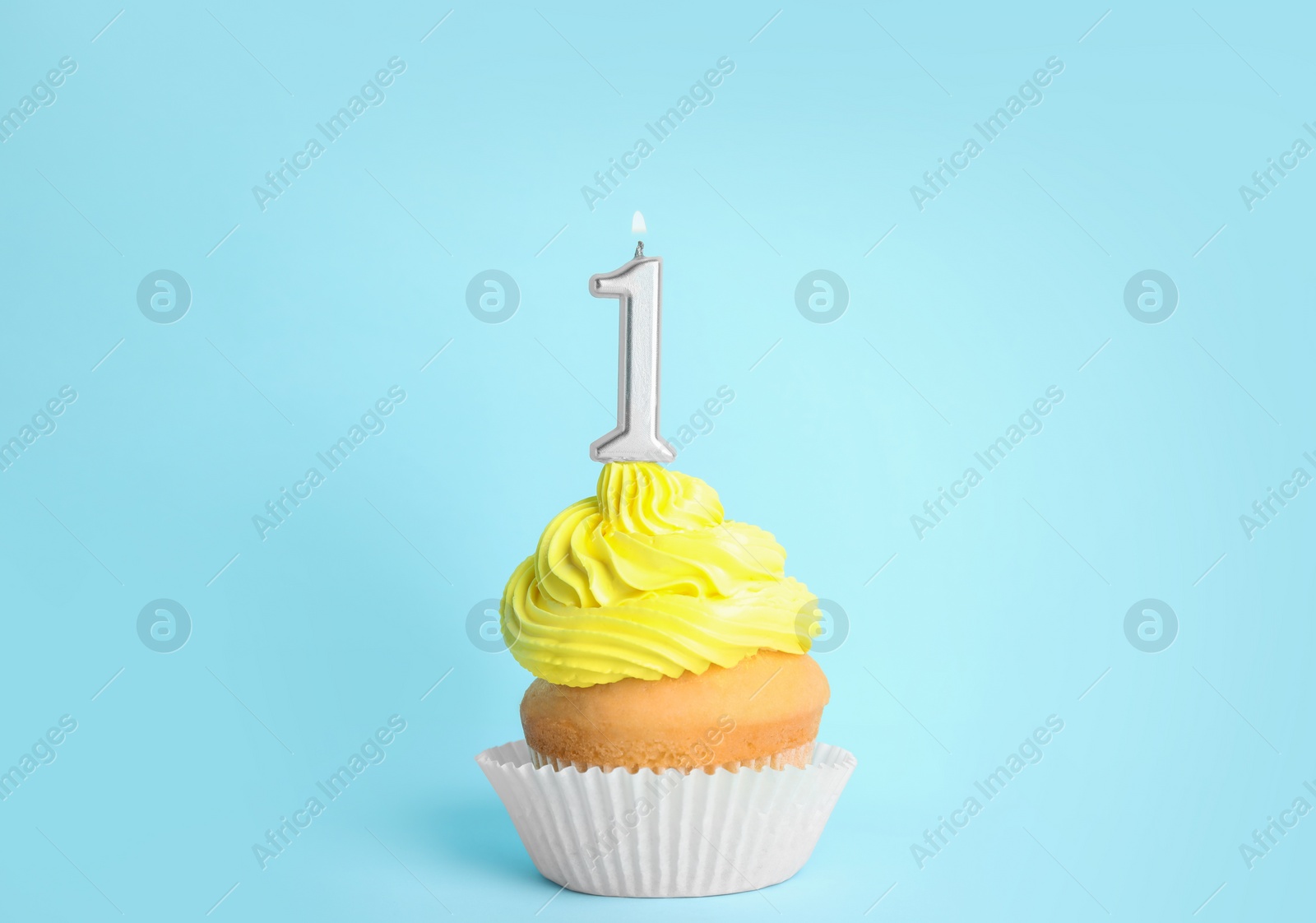 Photo of Birthday cupcake with number one candle on blue background