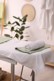 Comfortable massage table with clean towels in spa center