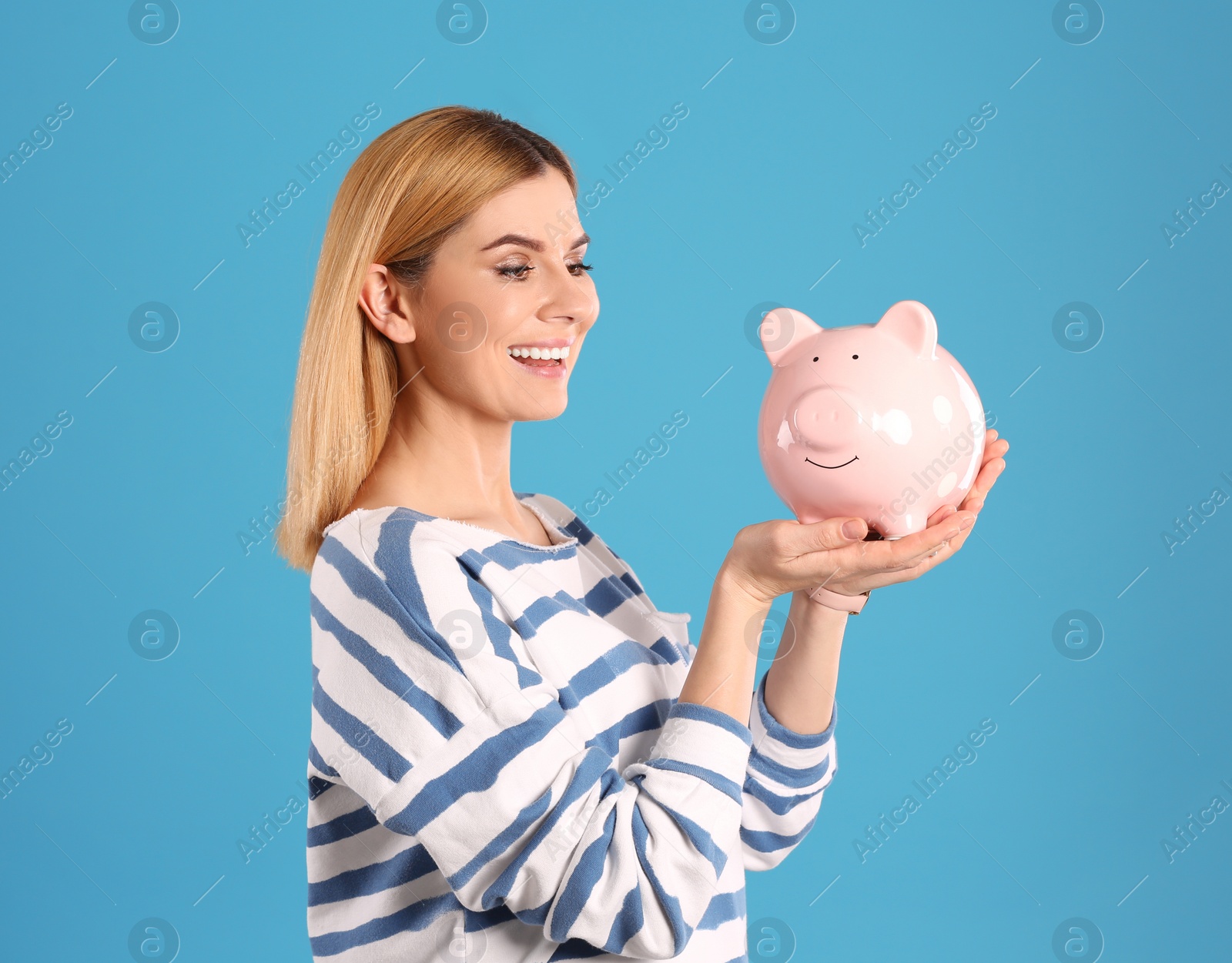 Photo of Woman with piggy bank on color background