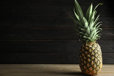 Photo of Fresh ripe juicy pineapple on wooden table. Space for text