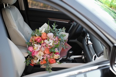 Photo of Beautiful flower bouquet inside car. Romantic surprise