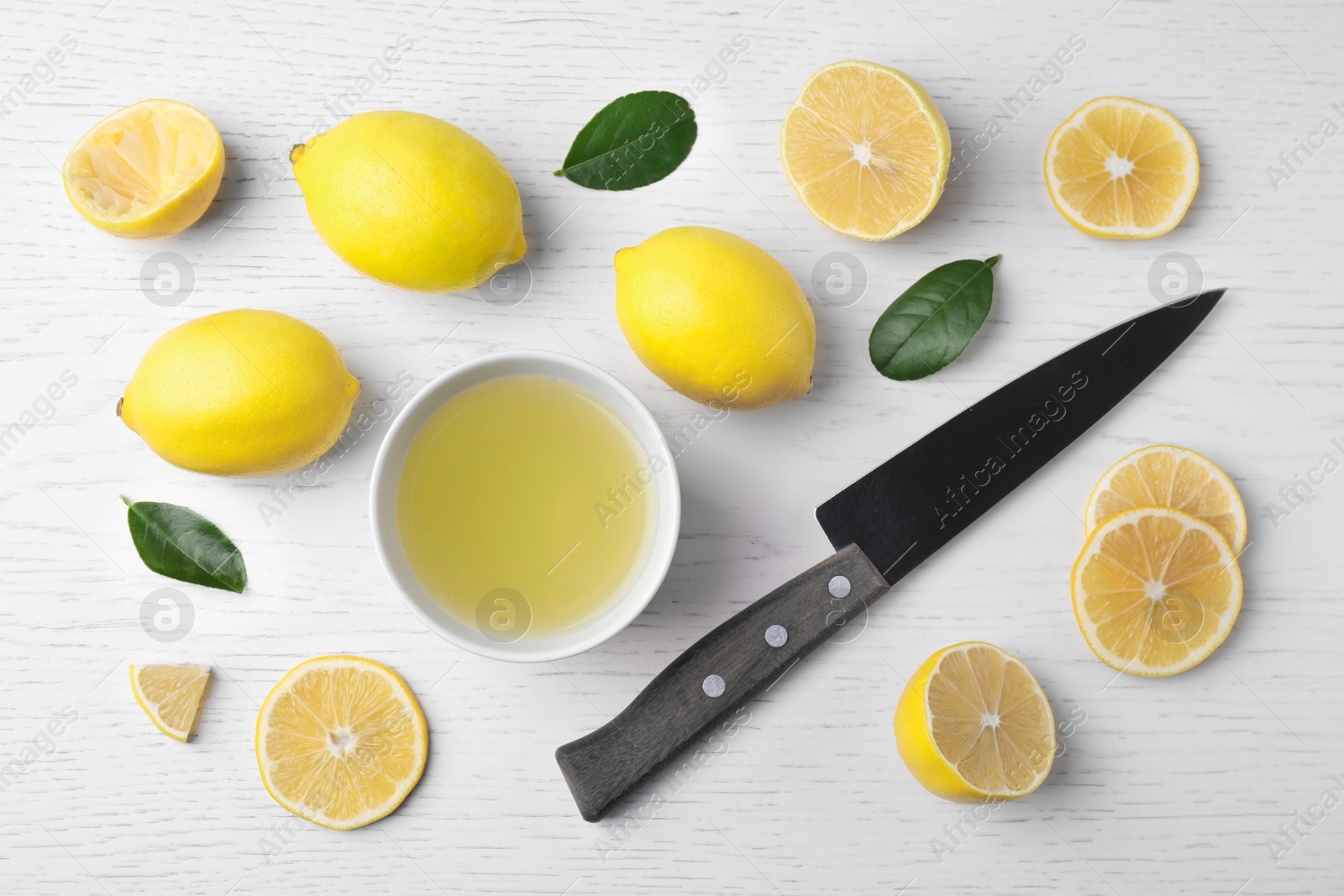 Photo of Flat lay composition with freshly squeezed lemon juice on white wooden table