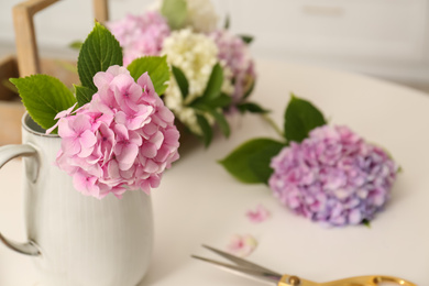Photo of Beautiful hydrangea flowers on white table, space for text. Interior design element