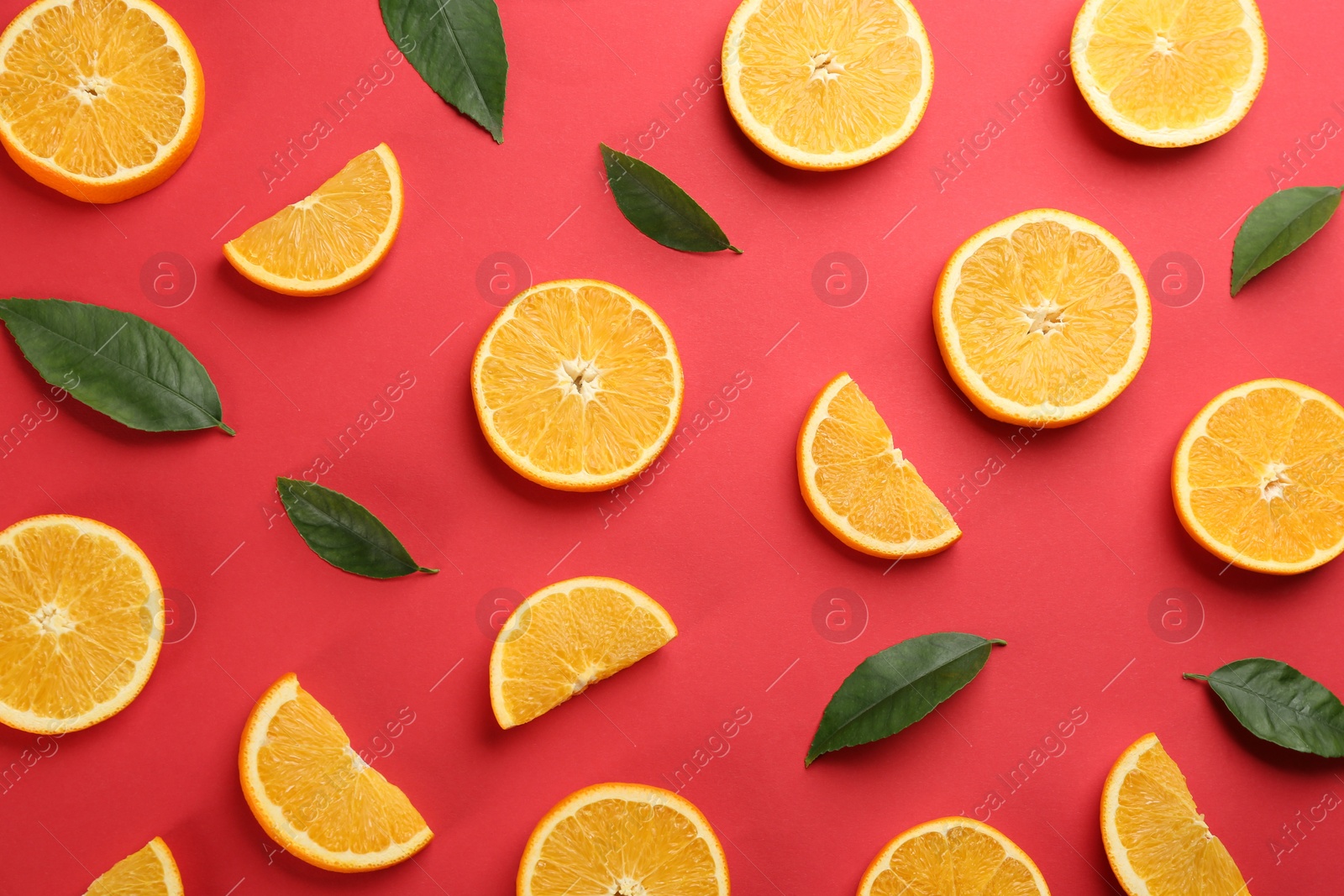 Photo of Slices of delicious oranges on red background, flat lay