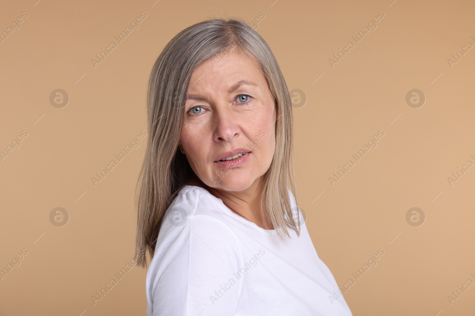 Photo of Portrait of surprised senior woman on beige background