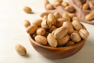 Photo of Ripe pecan nuts in dish served on table, closeup