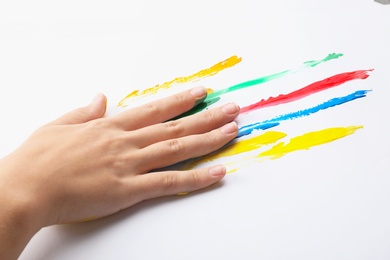 Child painting with hand on white background, closeup