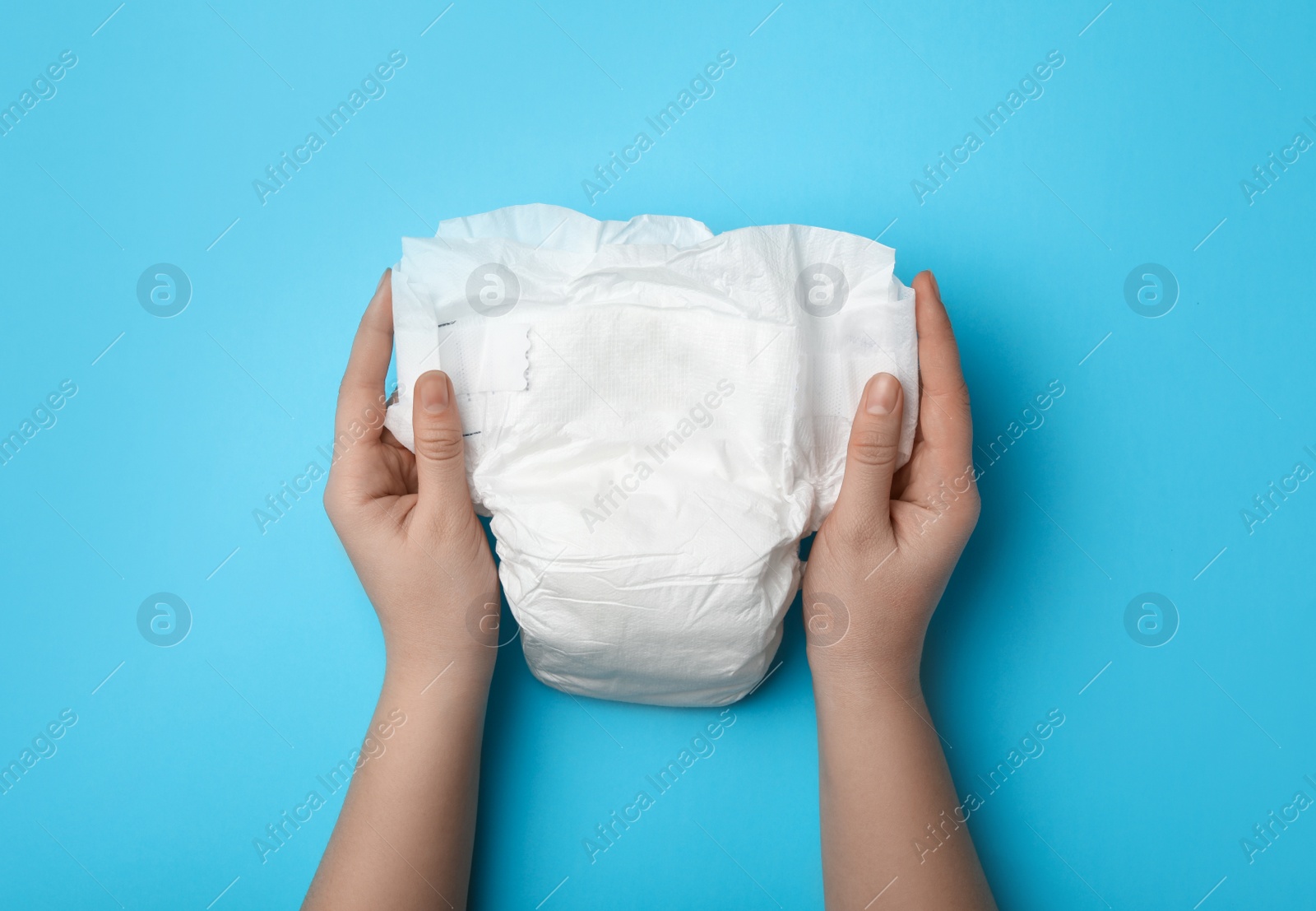 Photo of Woman with diaper on light blue background, closeup