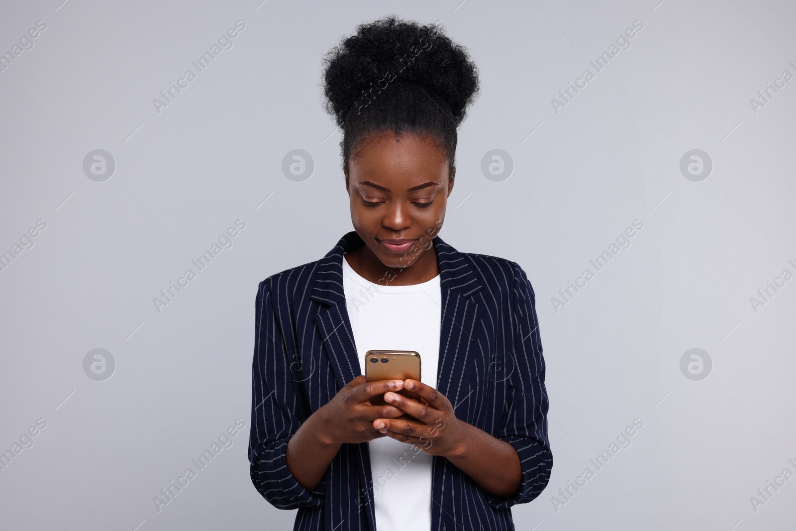 Photo of Beautiful young woman with smartphone on light grey background