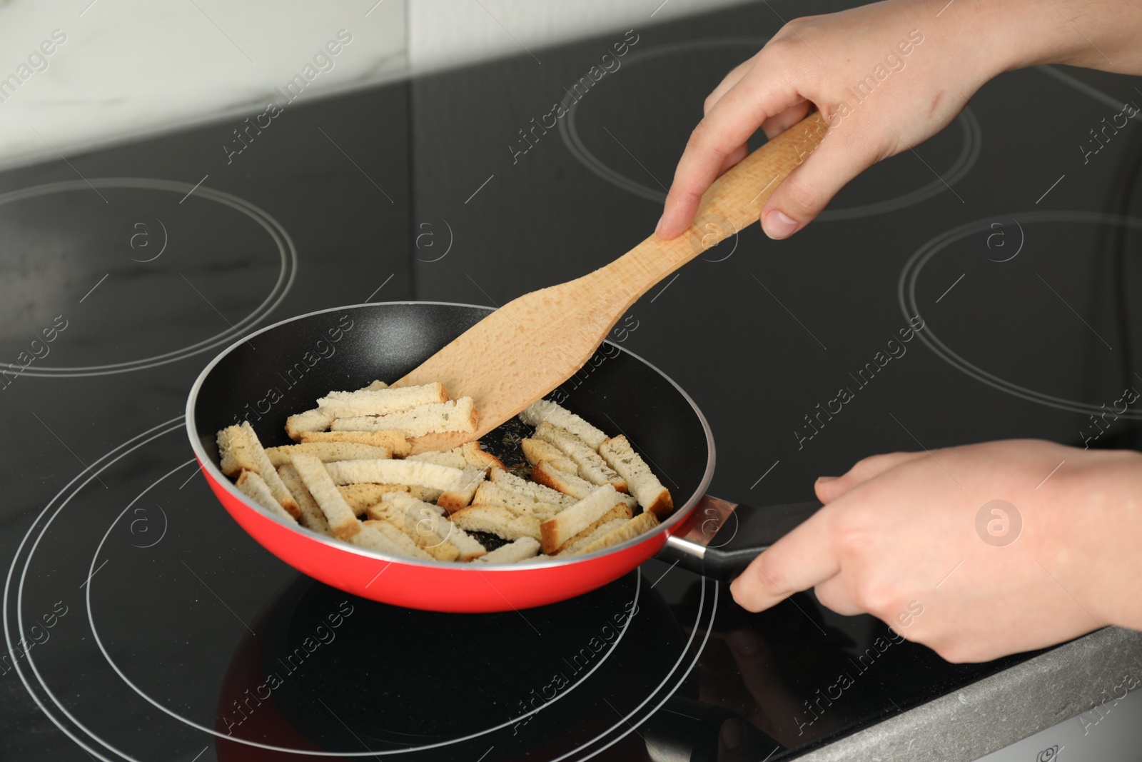 Photo of Woman cooking hard chucks on cooktop, closeup