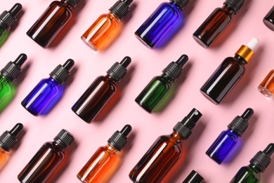 Photo of Bottles of essential oils on color background, flat lay. Cosmetic products