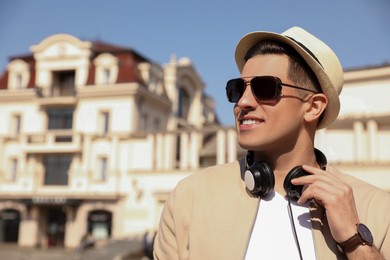 Photo of Happy man with headphones on city street