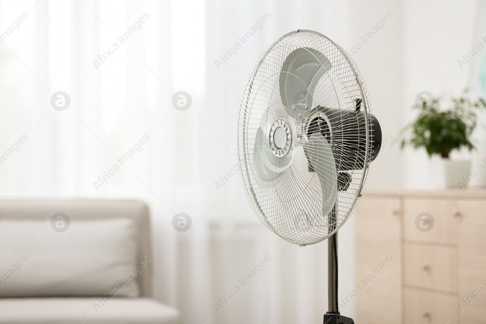 Photo of Modern electric fan in room. Space for text