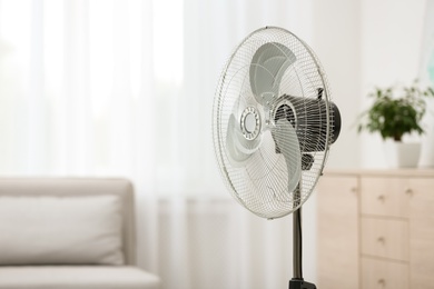 Photo of Modern electric fan in room. Space for text