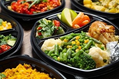 Photo of Lunchboxes with different meals on table, closeup. Healthy food delivery