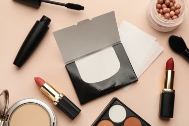 Photo of Flat lay composition with facial oil blotting tissues and makeup products on beige background. Mattifying wipes