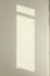 Photo of Blurred view of light and shadows from window on wall indoors