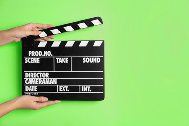 Image of Second assistant camera holding clapper board against chroma key background, closeup. Space for text