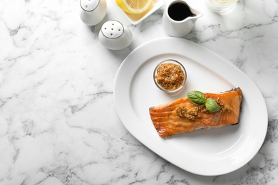 Tasty cooked salmon with mustard on plate, top view