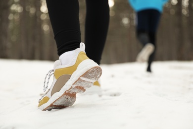 People running in winter forest, closeup. Outdoors sports exercises