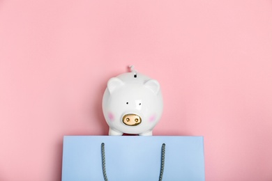 Photo of Flat lay composition with shopping bag and piggy bank on color background