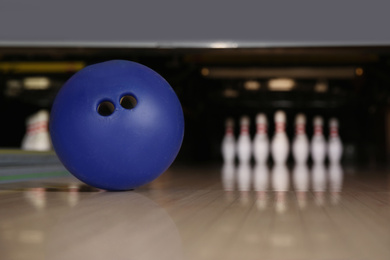 Blue ball on bowling lane in club. Space for text