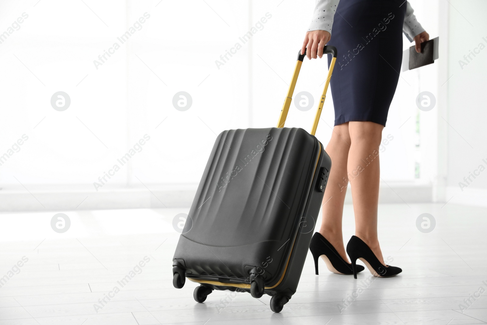 Photo of Businesswoman with black travel suitcase in airport. Space for text