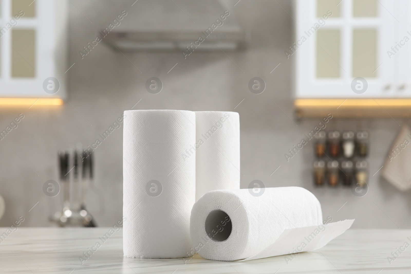 Photo of Rolls of paper towels on white marble table in kitchen