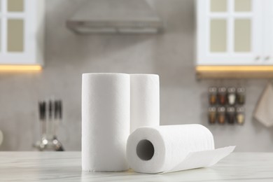 Photo of Rolls of paper towels on white marble table in kitchen