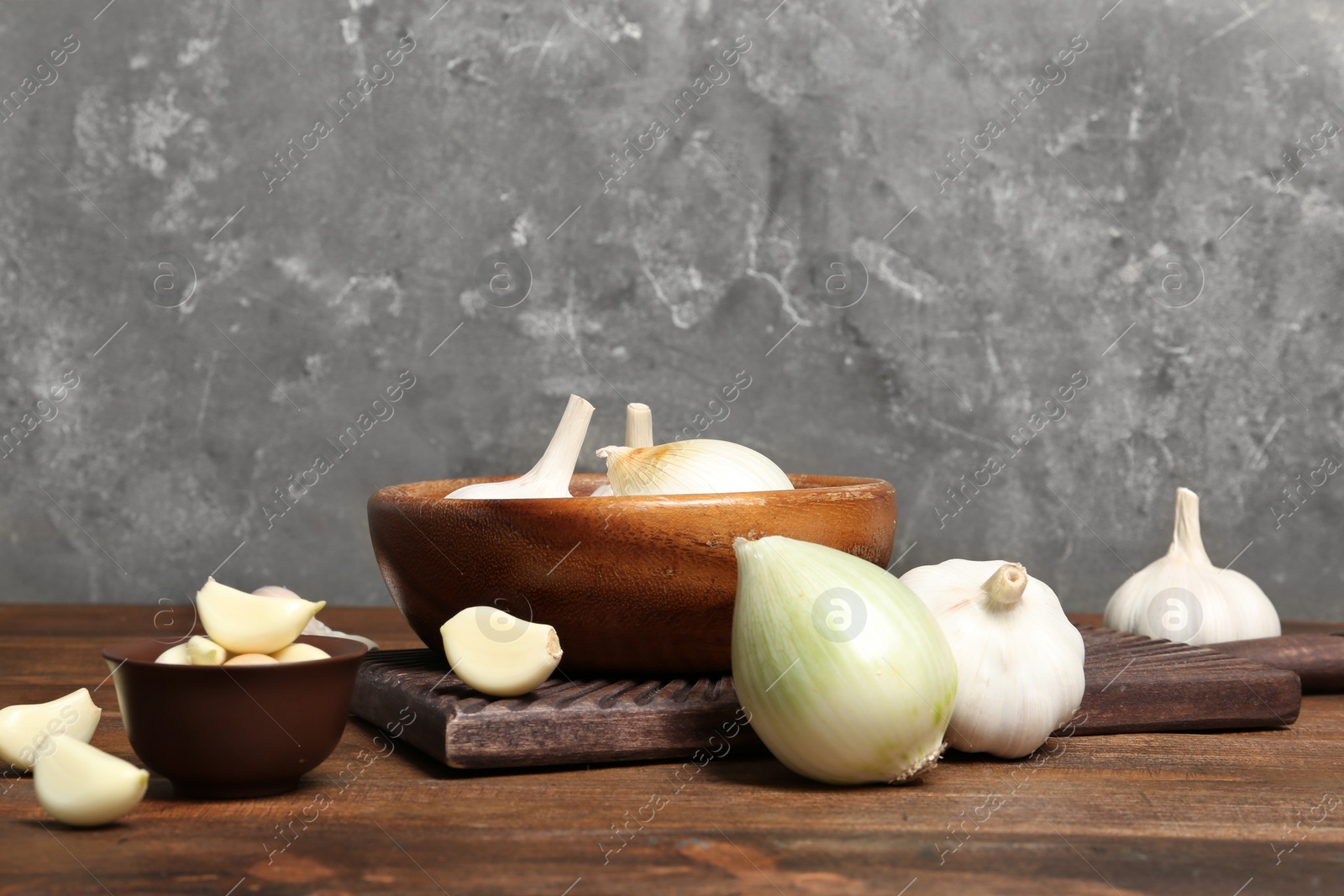 Photo of Composition with onion and garlic on wooden table