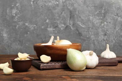 Photo of Composition with onion and garlic on wooden table