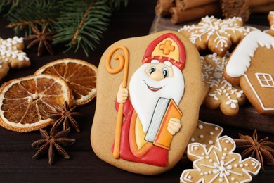 Photo of Tasty gingerbread cookies on wooden table, closeup. St. Nicholas Day celebration