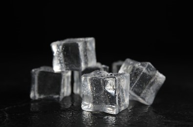 Photo of Ice cubes with water drops on black background, closeup