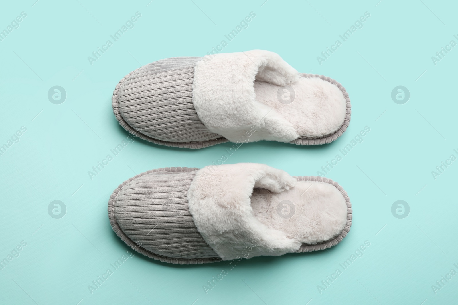 Photo of Pair of soft slippers on light blue background, flat lay
