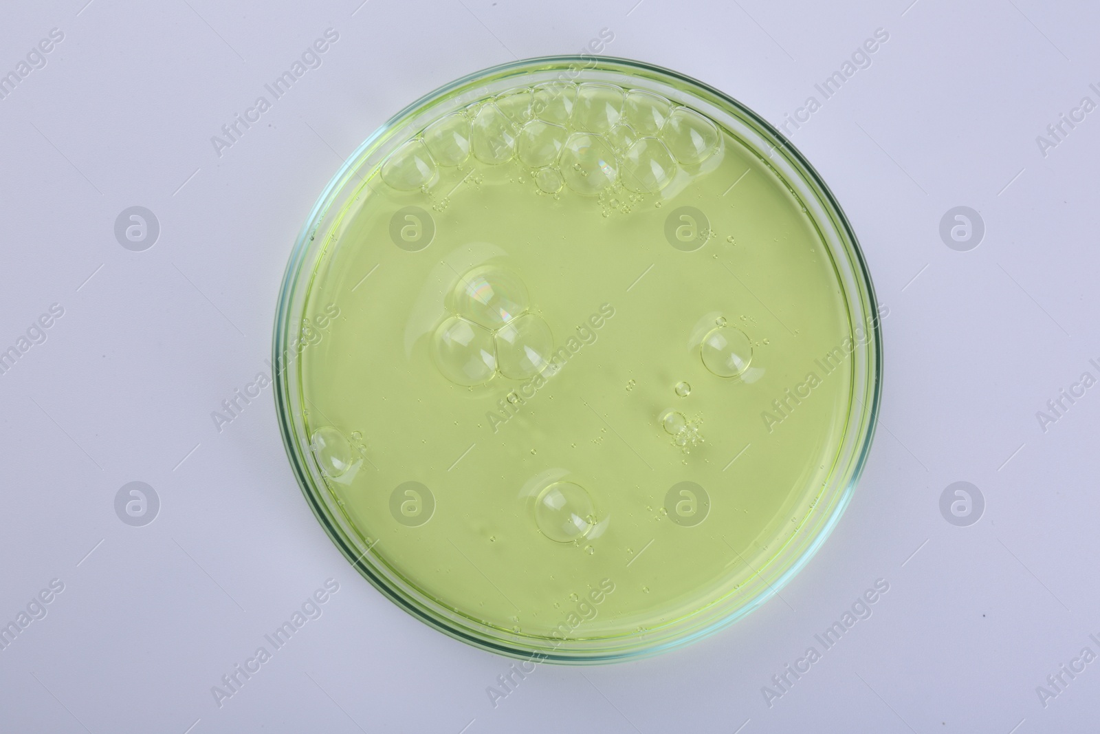 Photo of Petri dish with color liquid sample isolated on white, top view