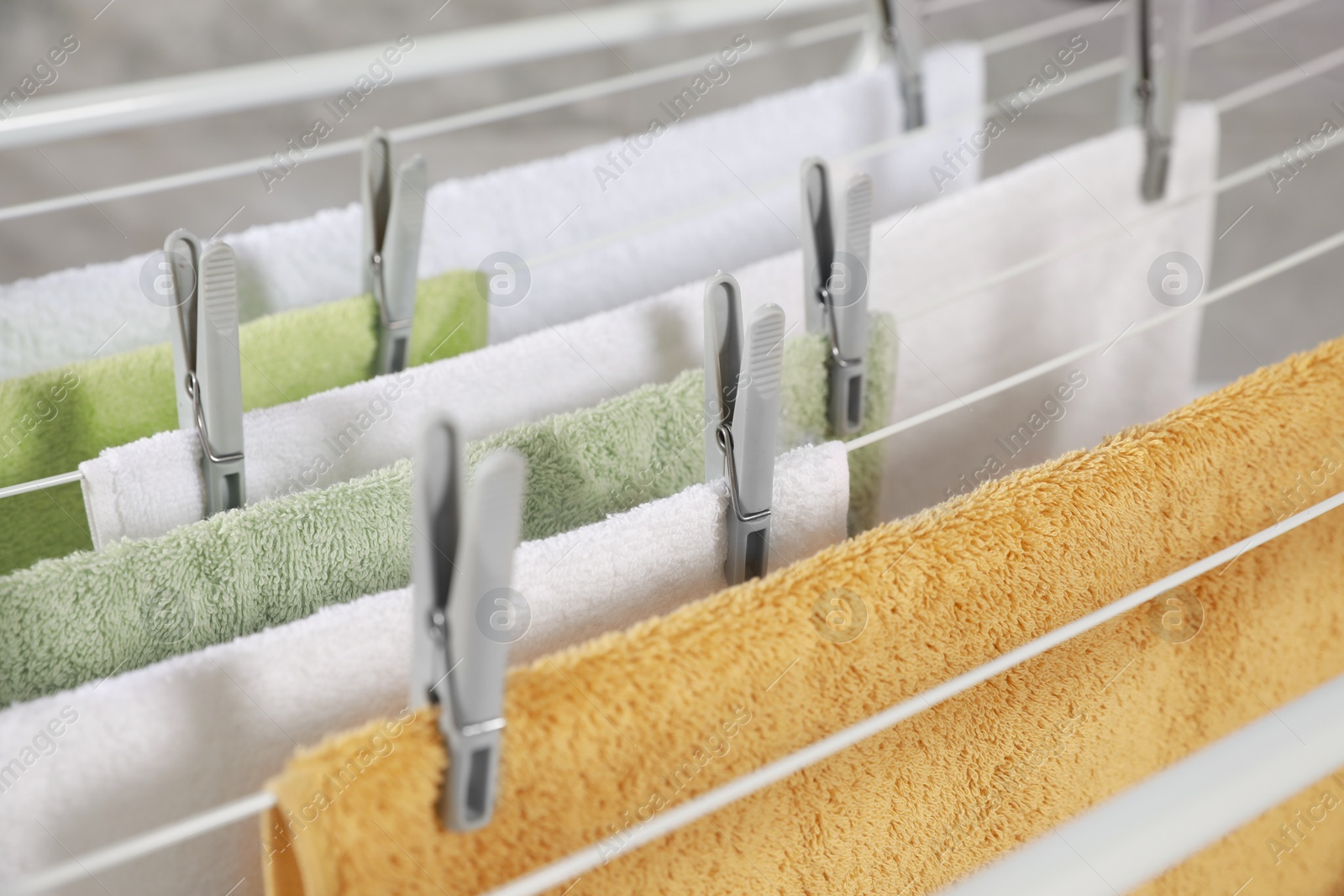 Photo of Clean terry towels hanging on drying rack, closeup